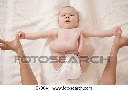Stock Image - An adult stretching a baby's arms. Fotosearch