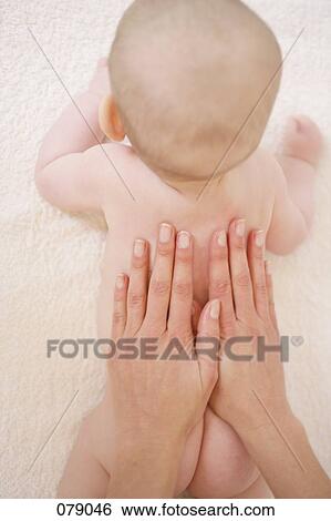 An adult touching a baby's back View Large Photo Image Stock Photograph - An adult touching a baby's back. Fotosearch