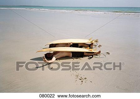 Two young men lying under surfboards on a beach, Australia View Large Photo Image Stock Image - Two young men lying under surfboards on a beach, Australia. Fotosearch