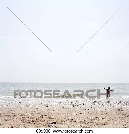 Girl with arms outstretched at beach View Large Photo Image Stock Photograph - Girl with arms outstretched at beach. Fotosearch