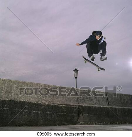 Man jumping in air with skateboard View Large Photo Image Stock Photography - Man jumping in air with skateboard. Fotosearch