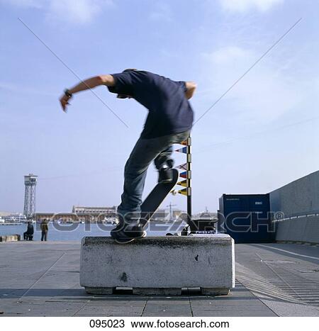 Man on skateboard balancing on stone block View Large Photo Image Stock Image - Man on skateboard balancing on stone block . Fotosearch