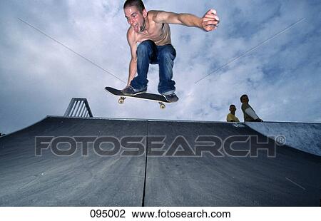 Man on skateboard jumping in air View Large Photo Image Stock Image - Man on skateboard jumping in air . Fotosearch