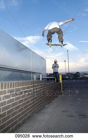 Man on skateboard jumping in mid-air View Large Photo Image Stock Photo - Man on skateboard jumping in mid-air . Fotosearch