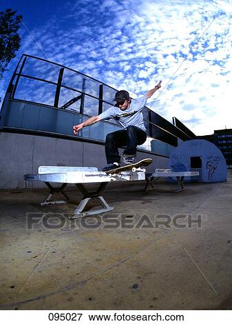 Man on skateboard jumping on ping-pong table View Large Photo Image Stock Photo - Man on skateboard jumping on ping-pong table. Fotosearch