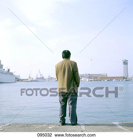 Man standing at harbor View Large Photo Image Stock Image - Man standing at harbor. Fotosearch