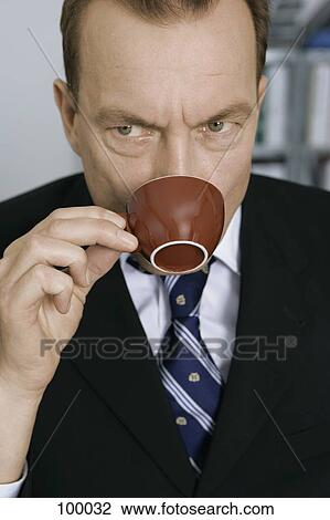 Businessman drinking out of coffee cup View Large Photo Image Stock Image - Businessman drinking out of coffee cup. Fotosearch