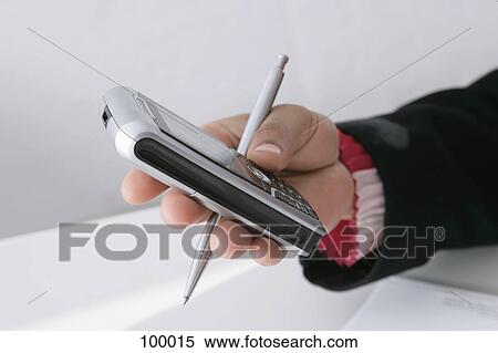 Stock Photography - Businesswoman holding pen and cell phone . Fotosearch