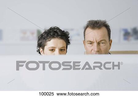 Man and woman looking at computer monitor View Large Photo Image Stock Photography - Man and woman looking at computer monitor. Fotosearch