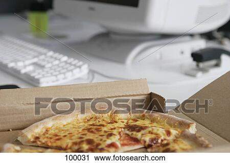 Stock Image - Pizza box on office desk. Fotosearch