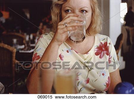 A mature adult woman drinking View Large Photo Image Stock Photography - A mature adult woman drinking. Fotosearch
