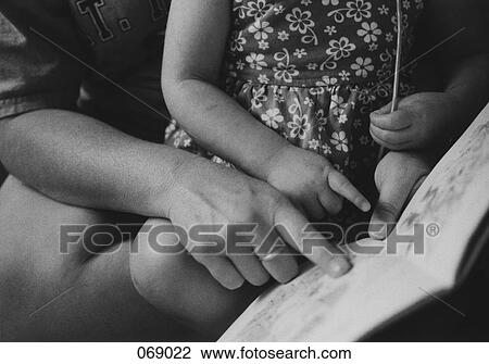 Stock Image - An adult reading to a child. Fotosearch