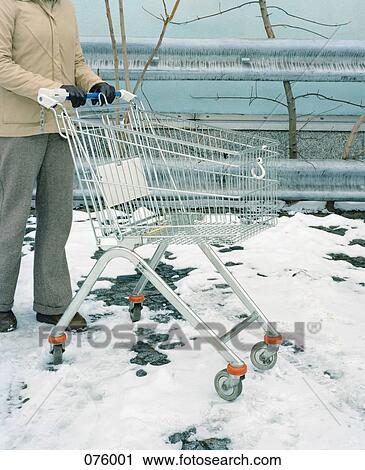 A person pushing a shopping cart in the snow View Large Photo Image Stock Image - A person pushing a shopping cart in the snow. Fotosearch