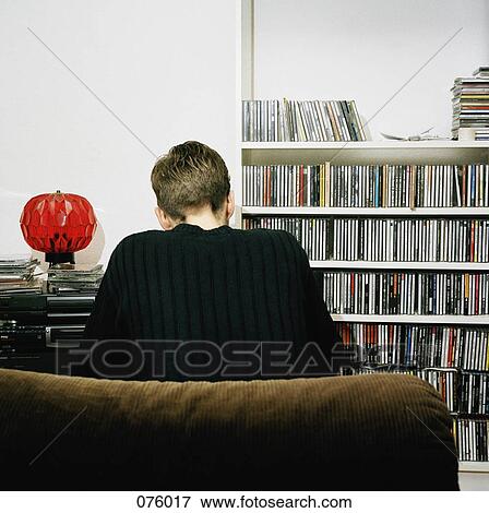A person sitting on a couch View Large Photo Image Stock Photo - A person sitting on a couch. Fotosearch