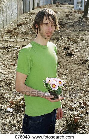 A young man holding flowers View Large Photo Image Stock Photo - A young man holding flowers. Fotosearch