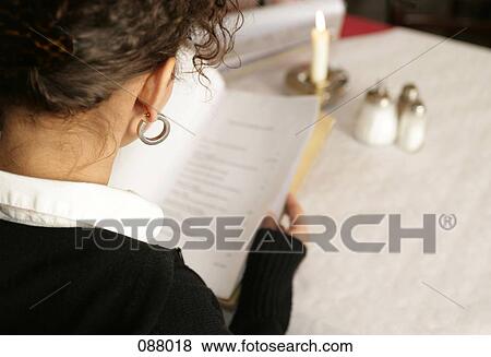 A woman reading a menu in a cafe View Large Photo Image Stock Photo - A woman reading a menu in a cafe. Fotosearch