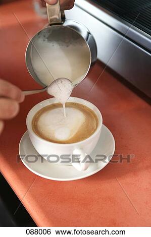 Stock Photograph - Barista pouring steamed milk. Fotosearch