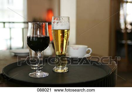 Stock Image - Glass of wine and beer on cafe table. Fotosearch