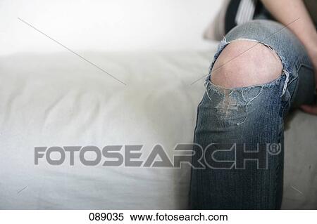 Stock Photography - Knee protruding through jeans. Fotosearch