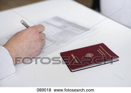 Man filling out form with German passport View Large Photo Image Stock Photo - Man filling out form with German passport. Fotosearch
