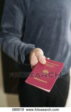 Man holding German passport View Large Photo Image Stock Photo - Man holding German passport. Fotosearch