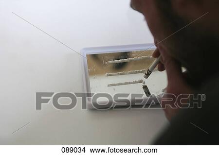 Man holding rolled bank note over lines of cocaine View Large Photo Image Picture - Man holding rolled bank note over lines of cocaine. Fotosearch