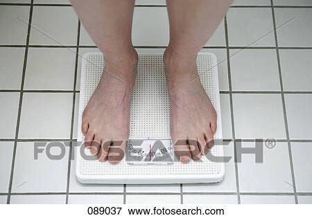 Woman standing on scale View Large Photo Image Stock Photo - Woman standing on scale. Fotosearch