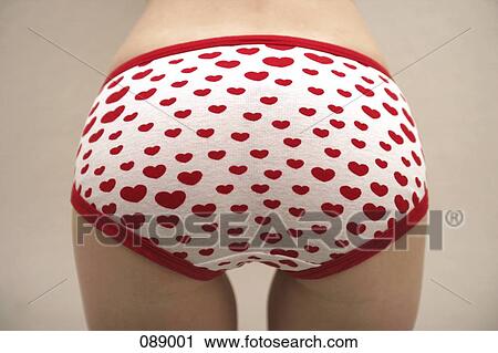 Stock Image - Woman wearing heart patterned underwear. Fotosearch