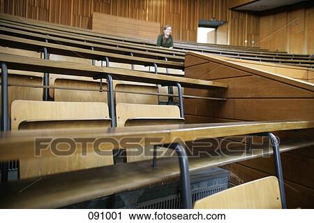 Stock Image - Woman sitting in lecture hall. Fotosearch