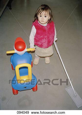 Girl holding mop and toy View Large Photo Image Stock Photo - Girl holding mop and toy. Fotosearch