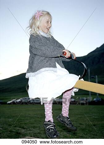 Girl sitting on a seesaw View Large Photo Image Stock Image - Girl sitting on a seesaw. Fotosearch