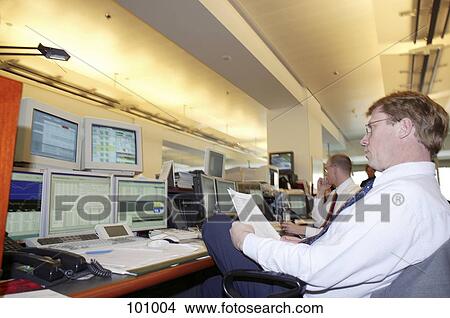 Picture - Businessman looking at computer screens . Fotosearch