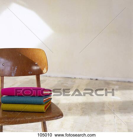 Stock Image - Stack of notebooks on chair. Fotosearch
