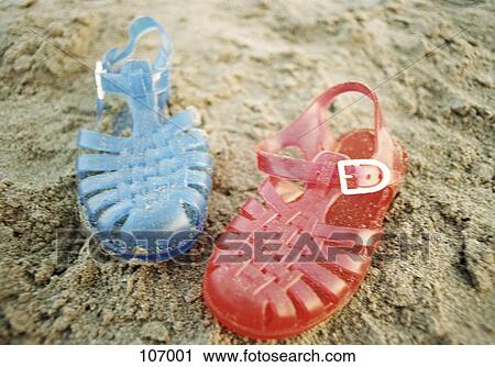 Stock Image - Plastic sandals on the beach. Fotosearch