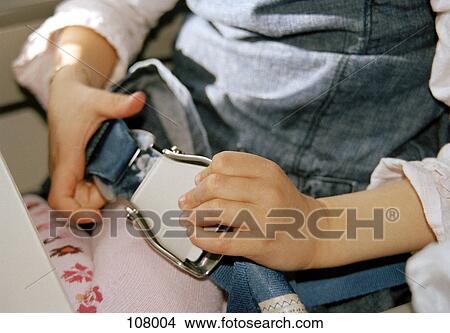 Child fastening airplane seat belt View Large Photo Image Picture - Child fastening airplane seat belt. Fotosearch