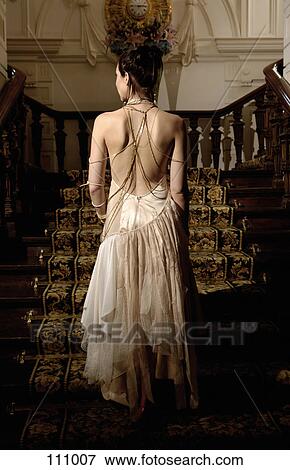 Woman in evening gown walking up stairs View Large Photo Image Stock Photo - Woman in evening gown walking up stairs. Fotosearch