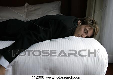 Businessman lying on bed View Large Photo Image Stock Photograph - Businessman lying on bed. Fotosearch