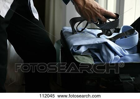 Businessman packing a suitcase View Large Photo Image Stock Photography - Businessman packing a suitcase. Fotosearch