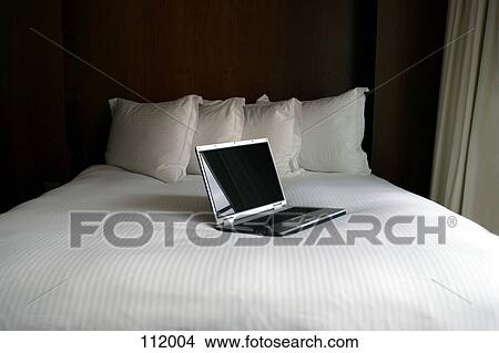 Picture - Laptop computer on bed. Fotosearch
