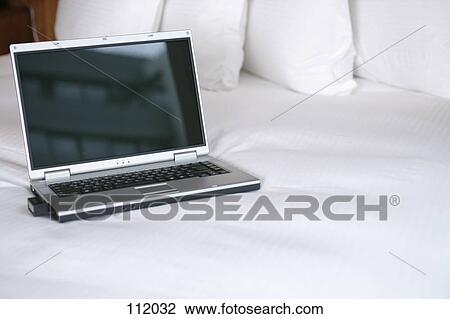 Stock Image - Laptop computer on bed. Fotosearch