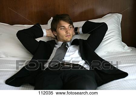 Man in suit lying down View Large Photo Image Stock Photography - Man in suit lying down. Fotosearch