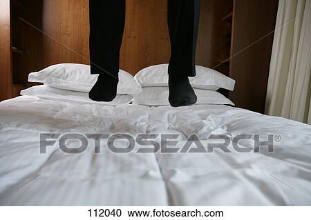 Man jumping on hotel bed View Large Photo Image Stock Image - Man jumping on hotel bed. Fotosearch