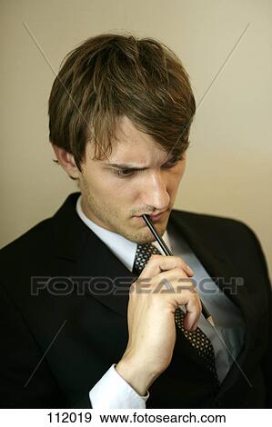Man with pen in his mouth View Large Photo Image Stock Photo - Man with pen in his mouth. Fotosearch