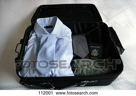 Stock Image - Open suitcase with clothing and passport. Fotosearch