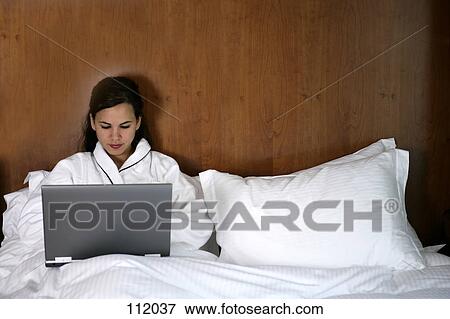 Woman using laptop computer in bed View Large Photo Image Stock Photo - Woman using laptop computer in bed. Fotosearch
