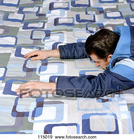 Man lying on bed View Large Photo Image Stock Photo - Man lying on bed. Fotosearch