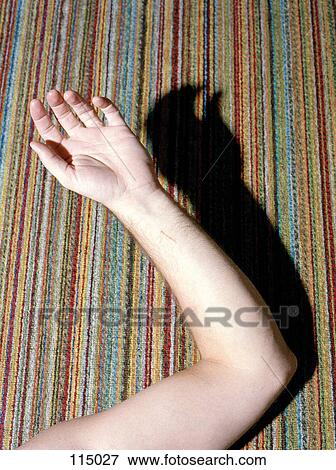 Stock Photo - Man’s arm leaning on multicolored carpet. Fotosearch