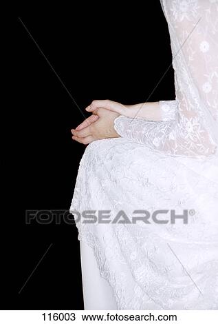 Stock Image - Bride sitting with hands clasped. Fotosearch