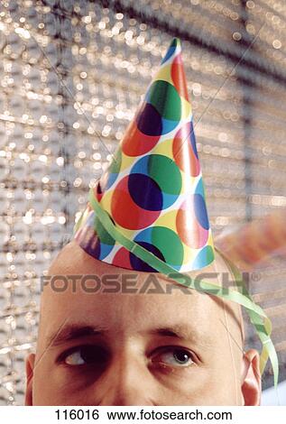 Close-up of man wearing party hat View Large Photo Image Stock Photograph - Close-up of man wearing party hat. Fotosearch