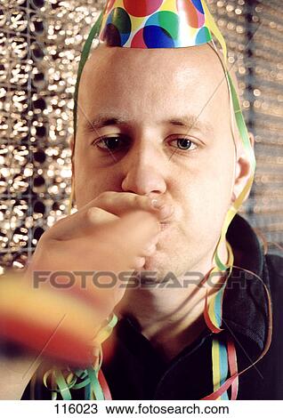 Man blowing party blower, wearing party hat View Large Photo Image Stock Image - Man blowing party blower, wearing party hat. Fotosearch